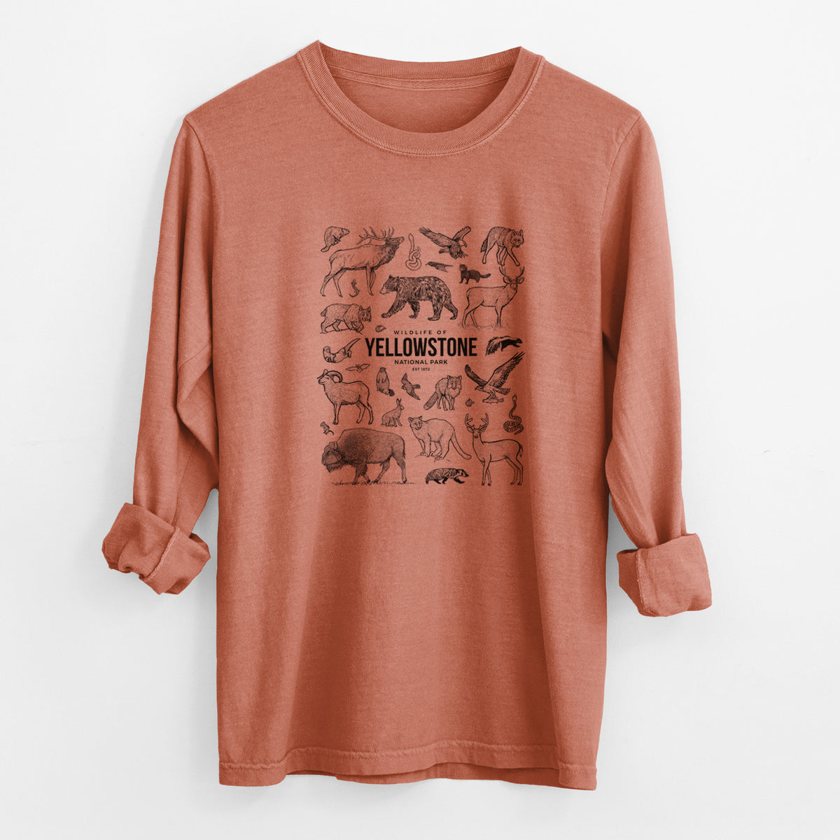 Yam burnt orange Comfort Colors long sleeve shirt laid flat with the cuffs rolled, printed with a collection of black ink wildlife illustrations surrounding the words Yellowstone National Park.