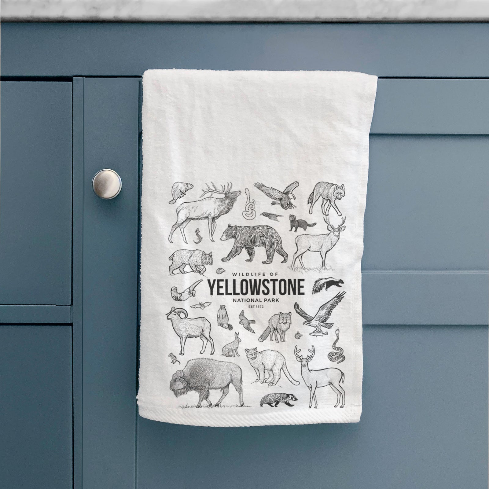 White hand towel printed with a collection of black ink wildlife illustrations surrounding the words Yellowstone National Park.