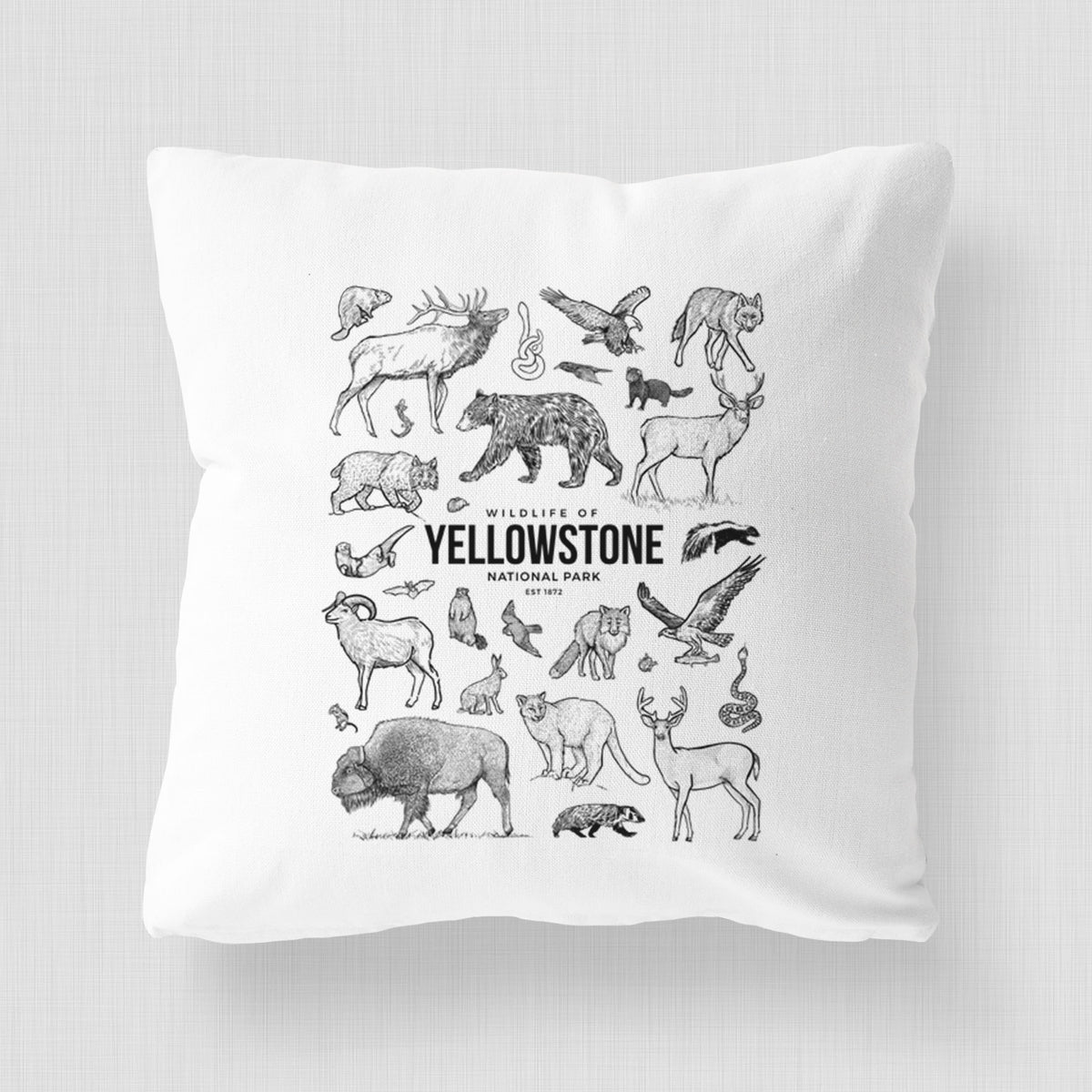 White pillow cover printed with a collection of black ink wildlife illustrations surrounding the words Yellowstone National Park.