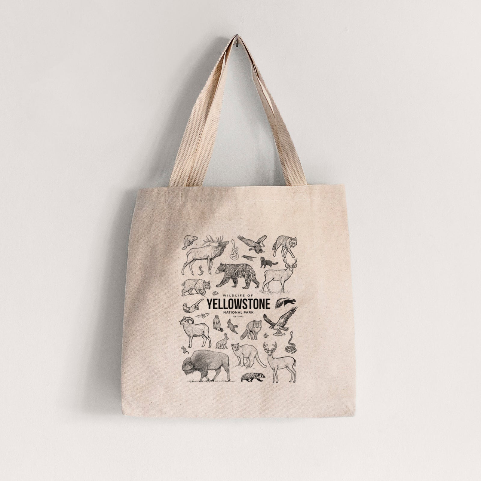 Natural canvas tote bag printed with a collection of black ink wildlife illustrations surrounding the words Yellowstone National Park.