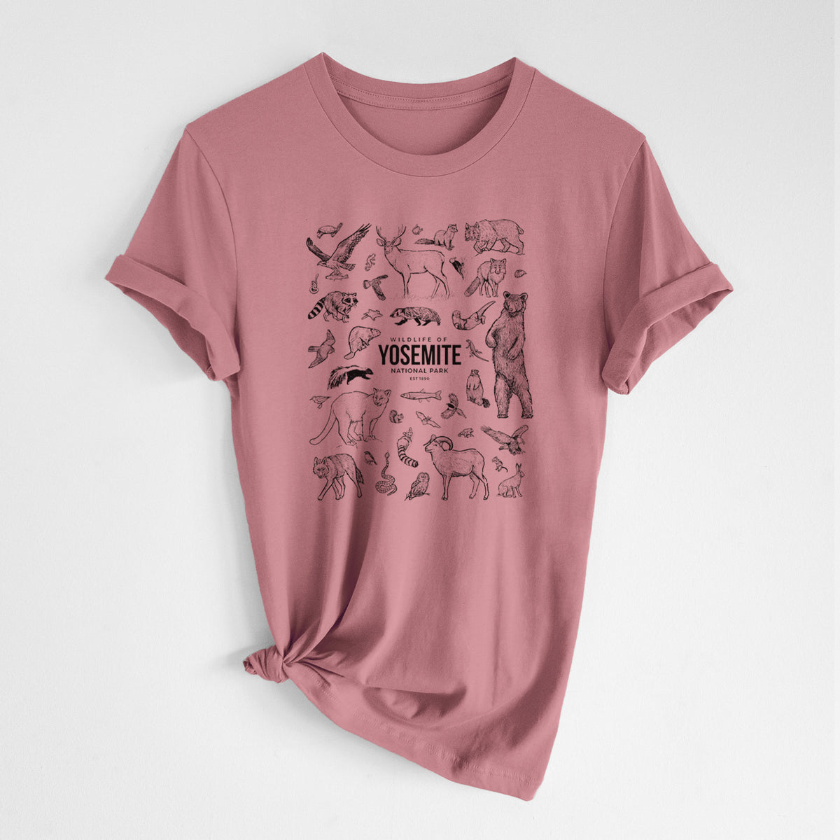 Mauve pink lightweight cotton t-shirt laid flat with the sleeves rolled, printed with a collection of black ink wildlife illustrations surrounding the words Yosemite National Park.