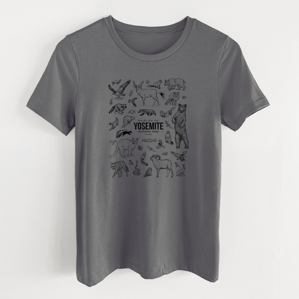 Asphalt women's relaxed fit cotton t-shirt laid flat, printed with a collection of black ink wildlife illustrations surrounding the words Yosemite National Park.