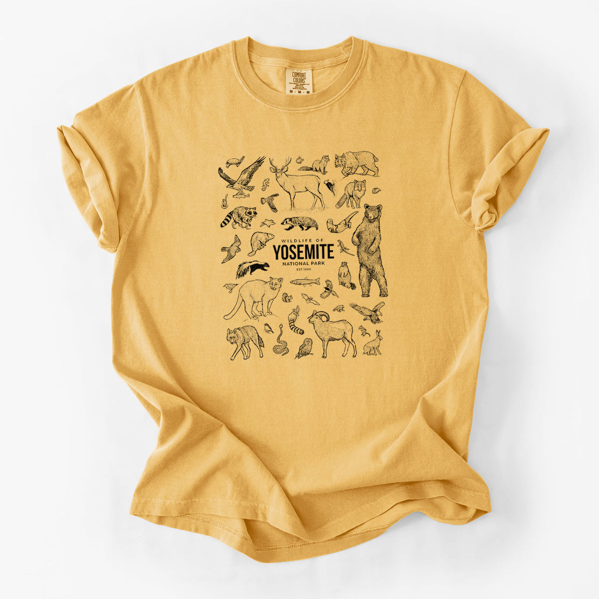 Golden wheat yellow Comfort Colors t-shirt laid flat, printed with a collection of black ink wildlife illustrations surrounding the words Yosemite National Park.