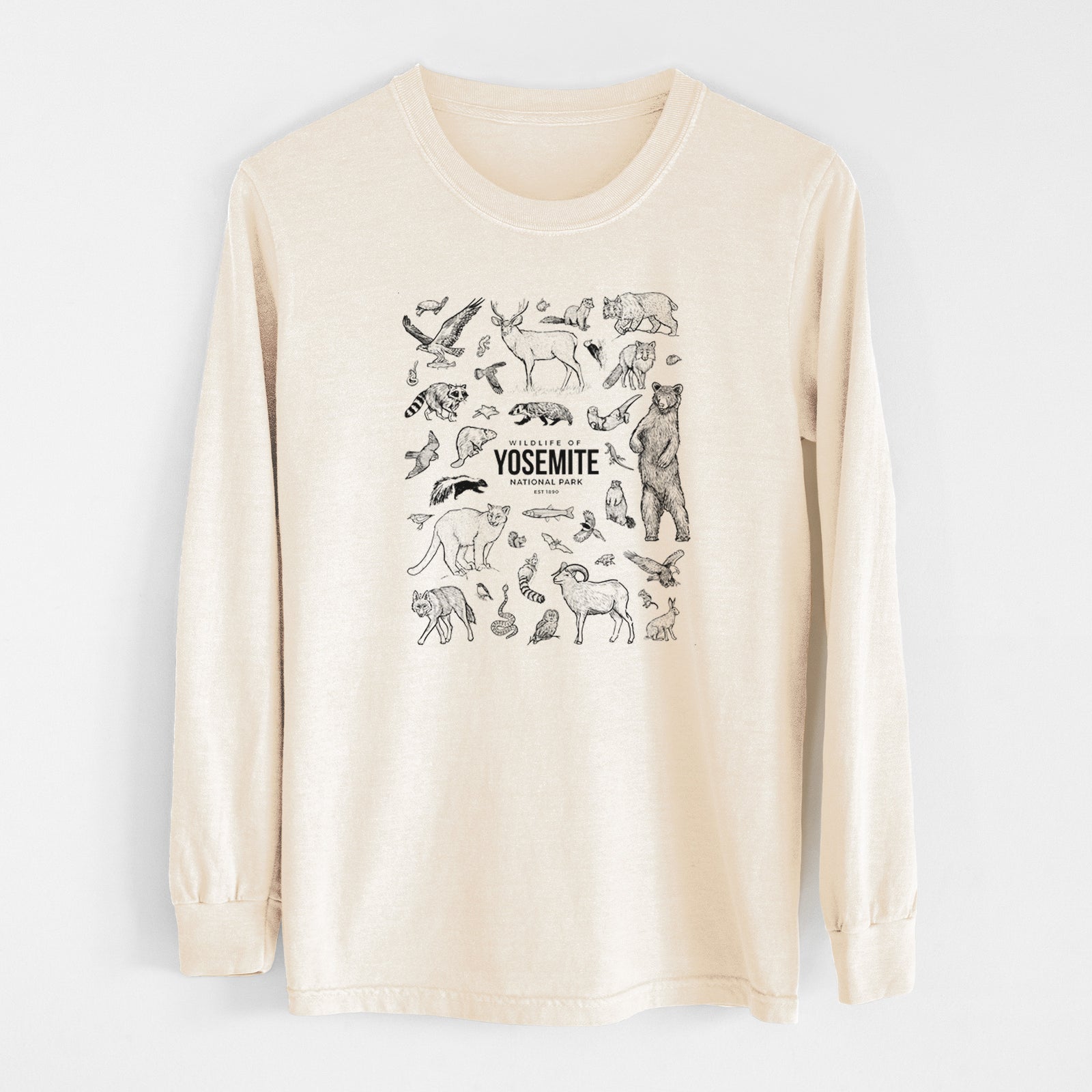 Ivory Comfort Colors long sleeve shirt laid flat, printed with a collection of black ink wildlife illustrations surrounding the words Yosemite National Park.