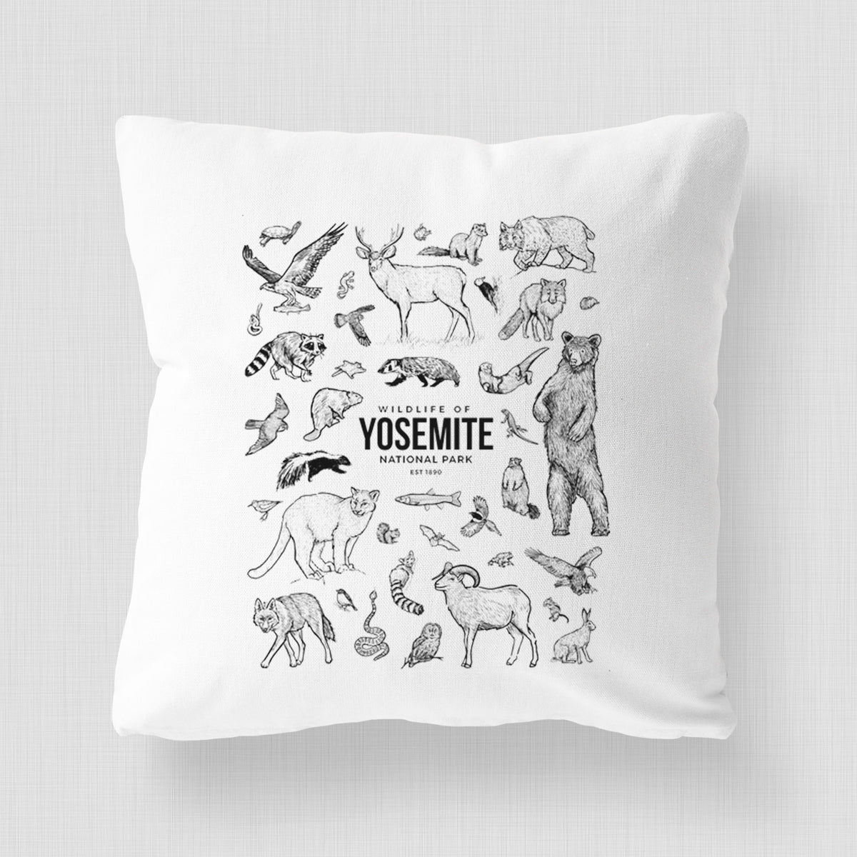 White pillow cover printed with a collection of black ink wildlife illustrations surrounding the words Yosemite National Park.
