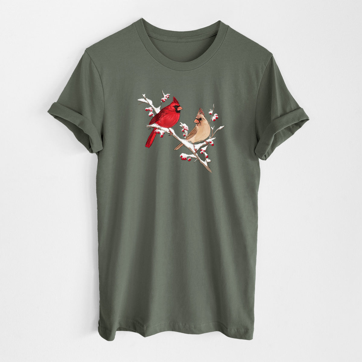 Military green lightweight cotton t-shirt laid flat, printed with a full-color illustration of a male and female northern cardinal perched on a snowy branch with red berries.