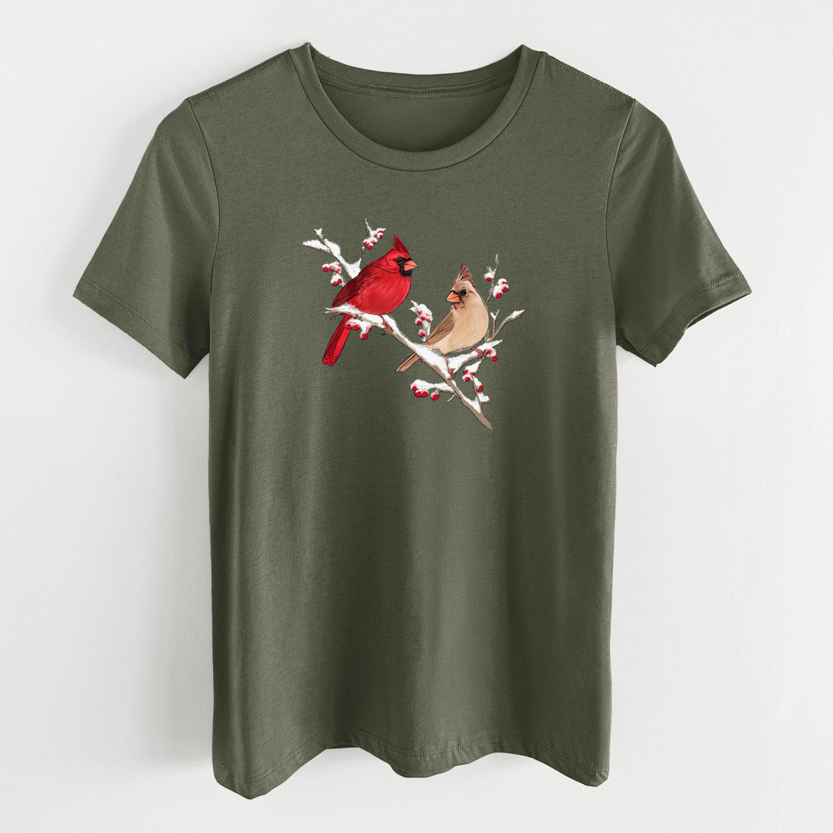 Military green women's relaxed fit cotton t-shirt laid flat, printed with a full-color illustration of a male and female northern cardinal perched on a snowy branch with red berries.