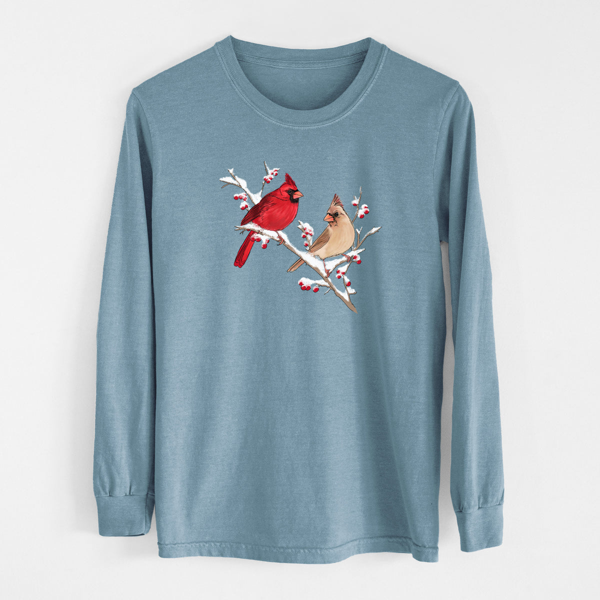 Steel blue Comfort Colors long sleeve shirt laid flat, printed with a full-color illustration of a male and female northern cardinal perched on a snowy branch with red berries.
