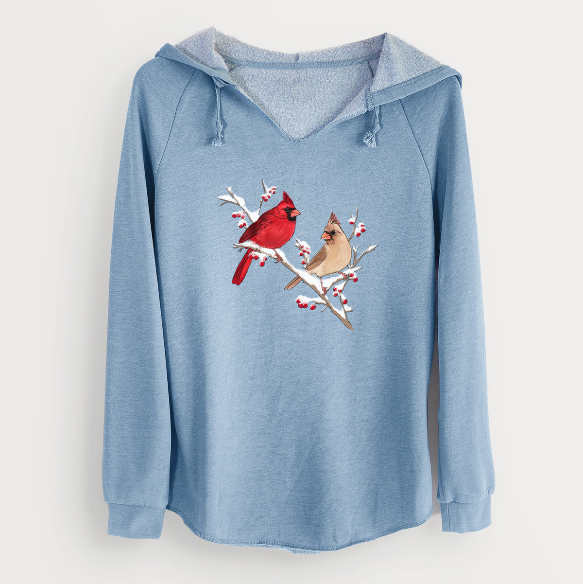 Misty blue women's Cali Wave hooded sweatshirt laid flat, printed with a full-color illustration of a male and female northern cardinal perched on a snowy branch with red berries.