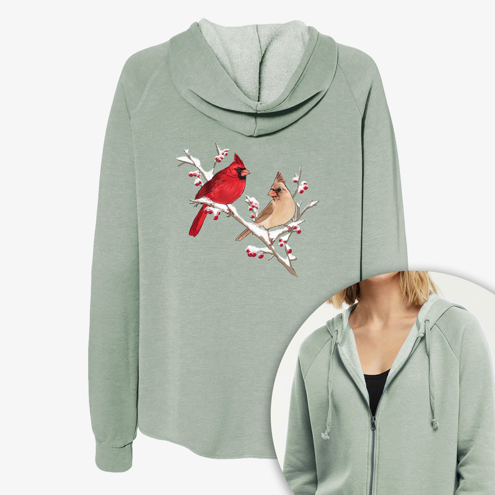 Women's Cali Wave zip-up sweatshirt printed with a full-color illustration of a male and female northern cardinal perched on a snowy branch with red berries, with a close-up of the zipper.