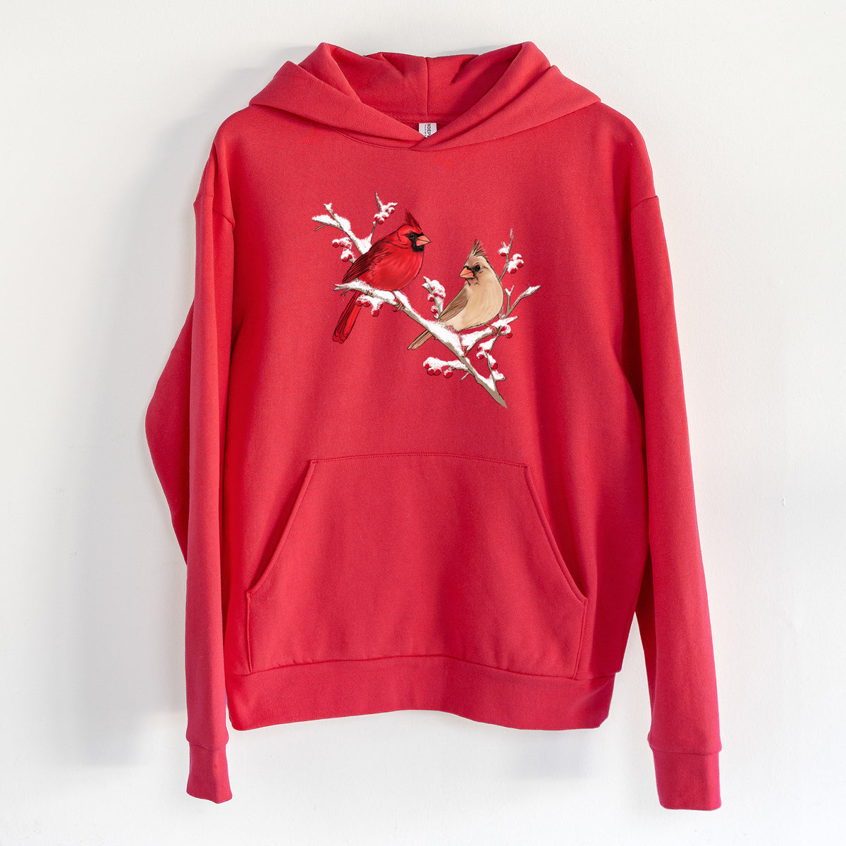 Winter Cardinals - Statement Midweight Hoodie in Cherry Red, hanging on a white wall, with a front kangaroo pocket and no drawcords.