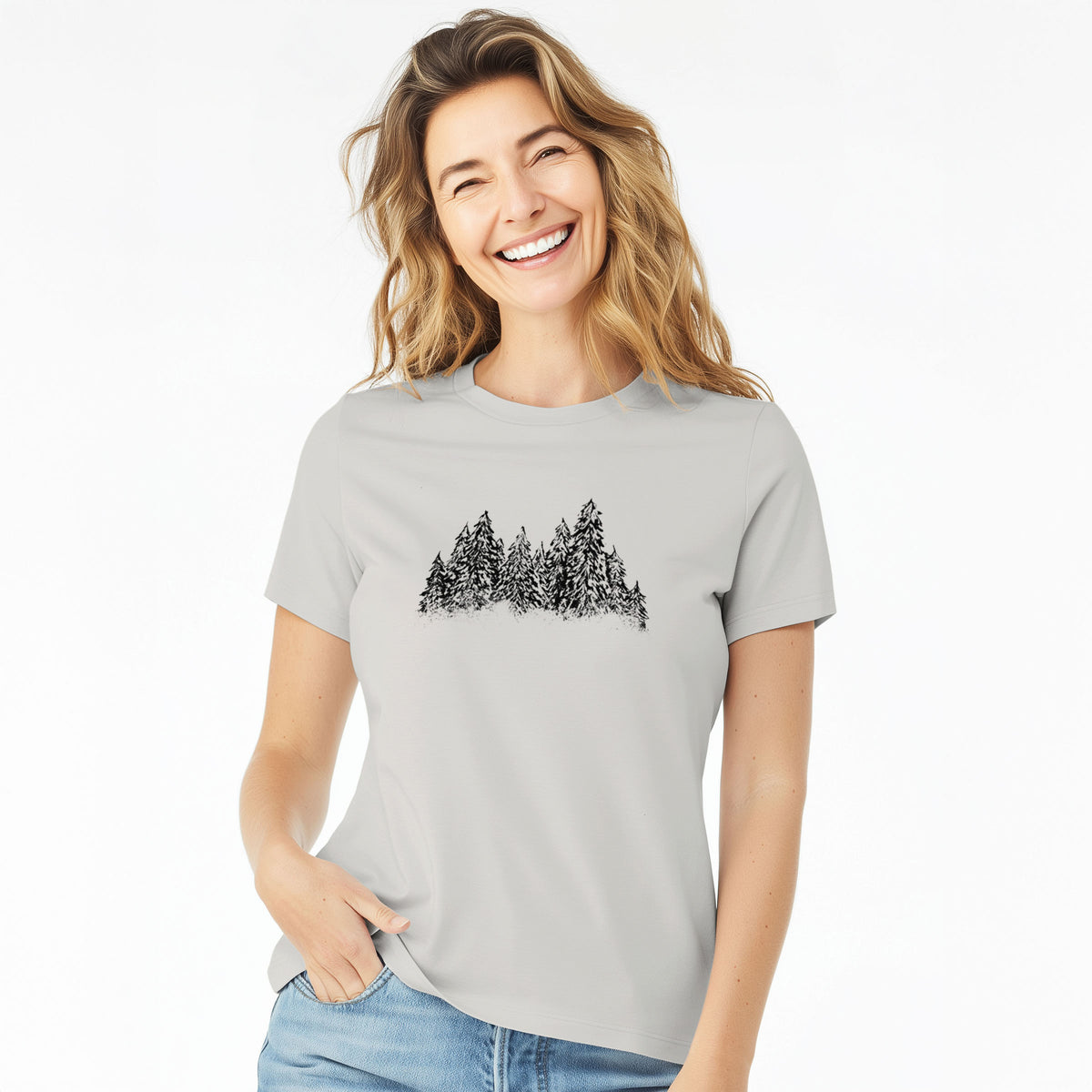 Woman wearing a lunar grey women's relaxed fit cotton t-shirt printed with a black ink illustration of a row of snow-dusted evergreen trees.