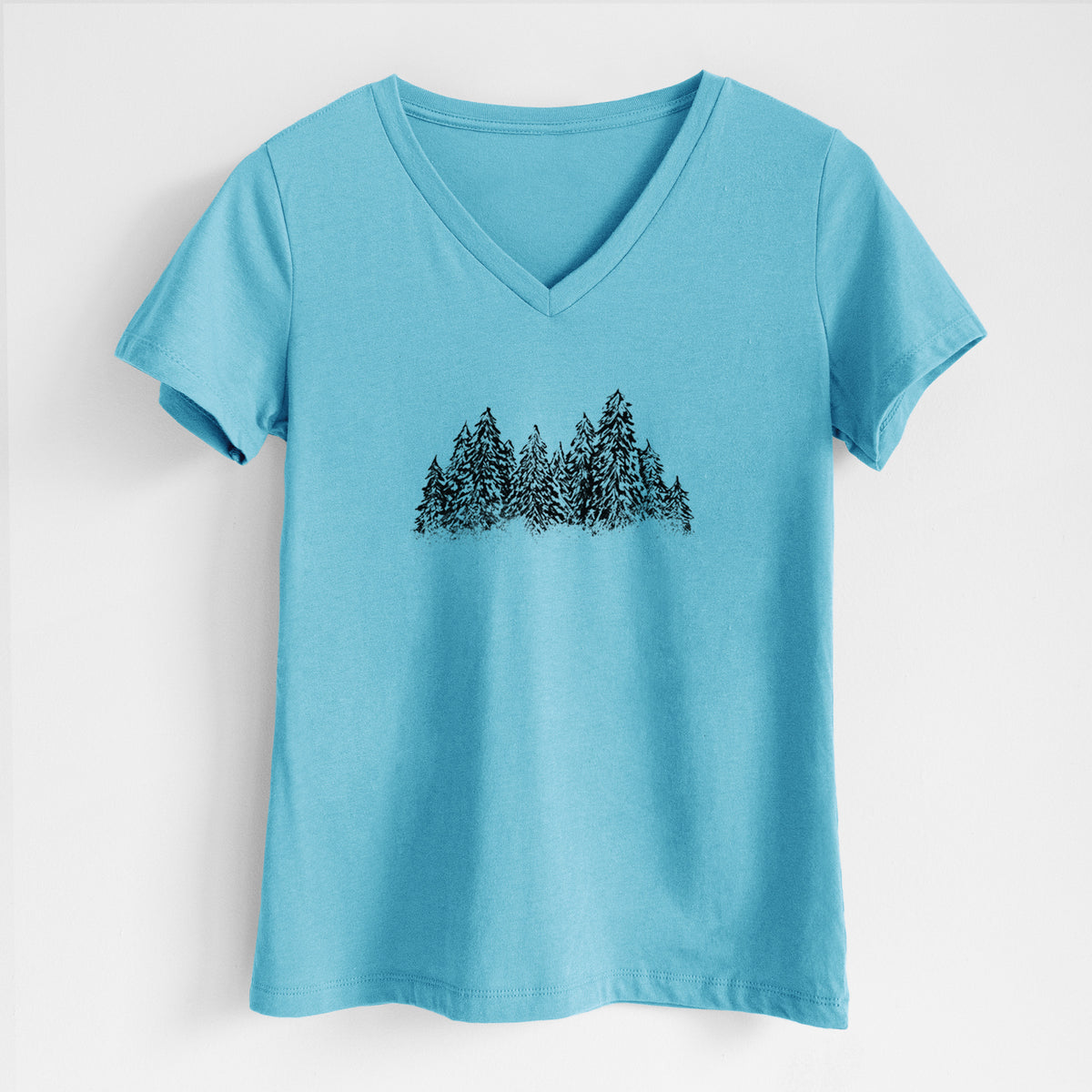 Turquoise women's relaxed fit cotton V-neck t-shirt laid flat, printed with a black ink illustration of a row of snow-dusted evergreen trees.