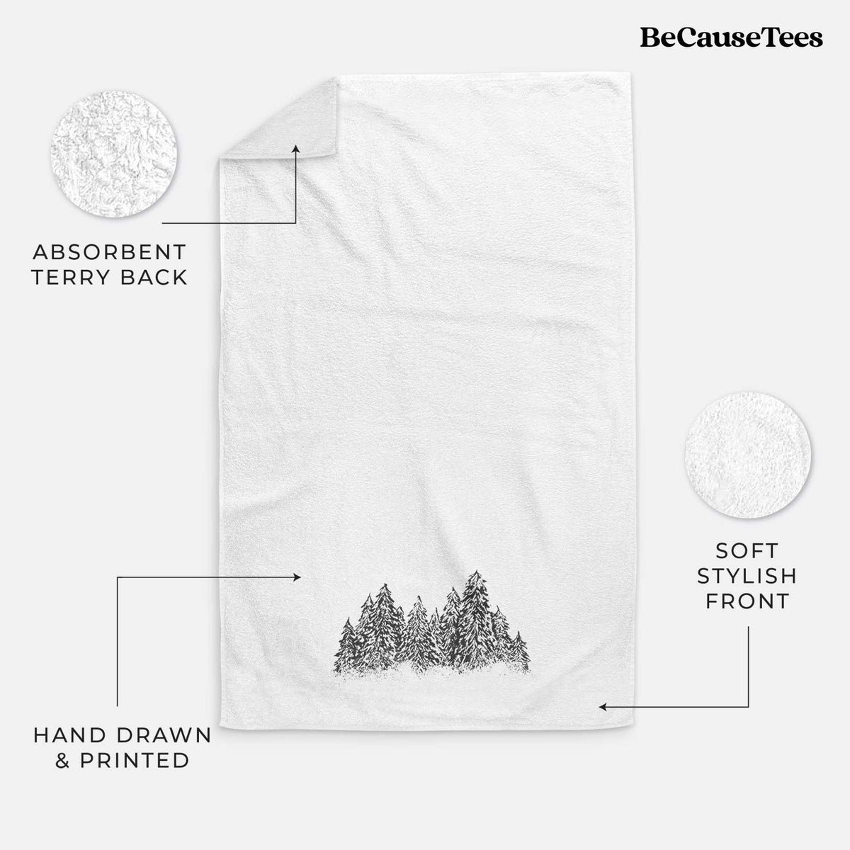 White hand towel printed with a black ink illustration of a row of snow-dusted evergreen trees.