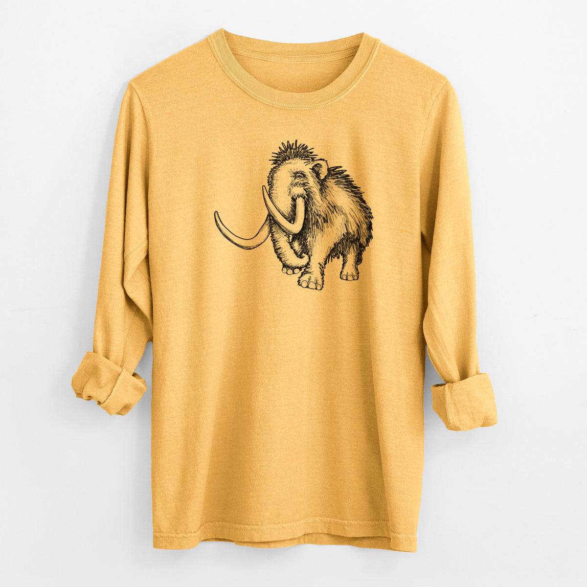 Golden wheat yellow Comfort Colors long sleeve shirt laid flat with the cuffs rolled, printed with a black ink illustration of a woolly mammoth with long curved tusks.