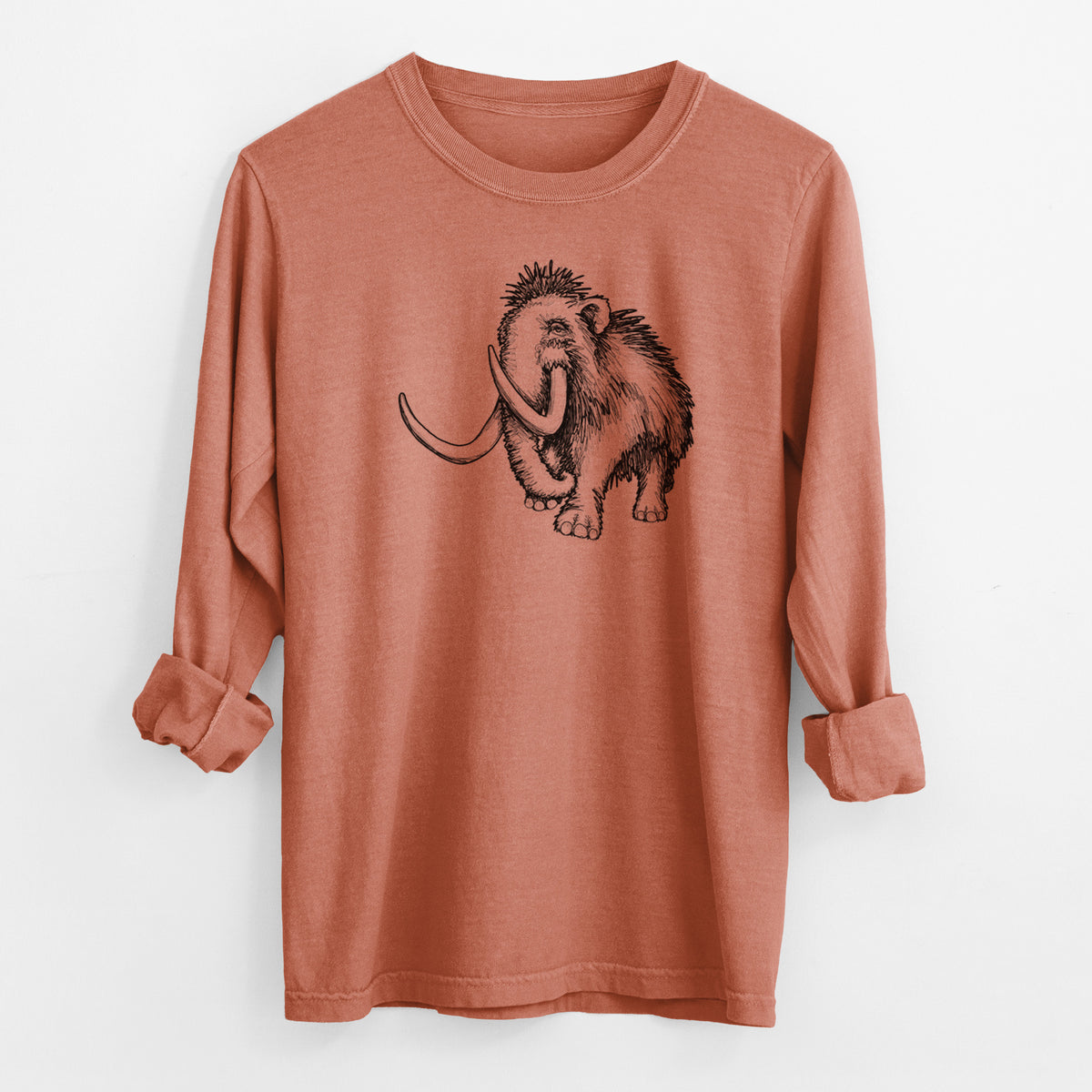 Yam burnt orange Comfort Colors long sleeve shirt laid flat with the cuffs rolled, printed with a black ink illustration of a woolly mammoth with long curved tusks.