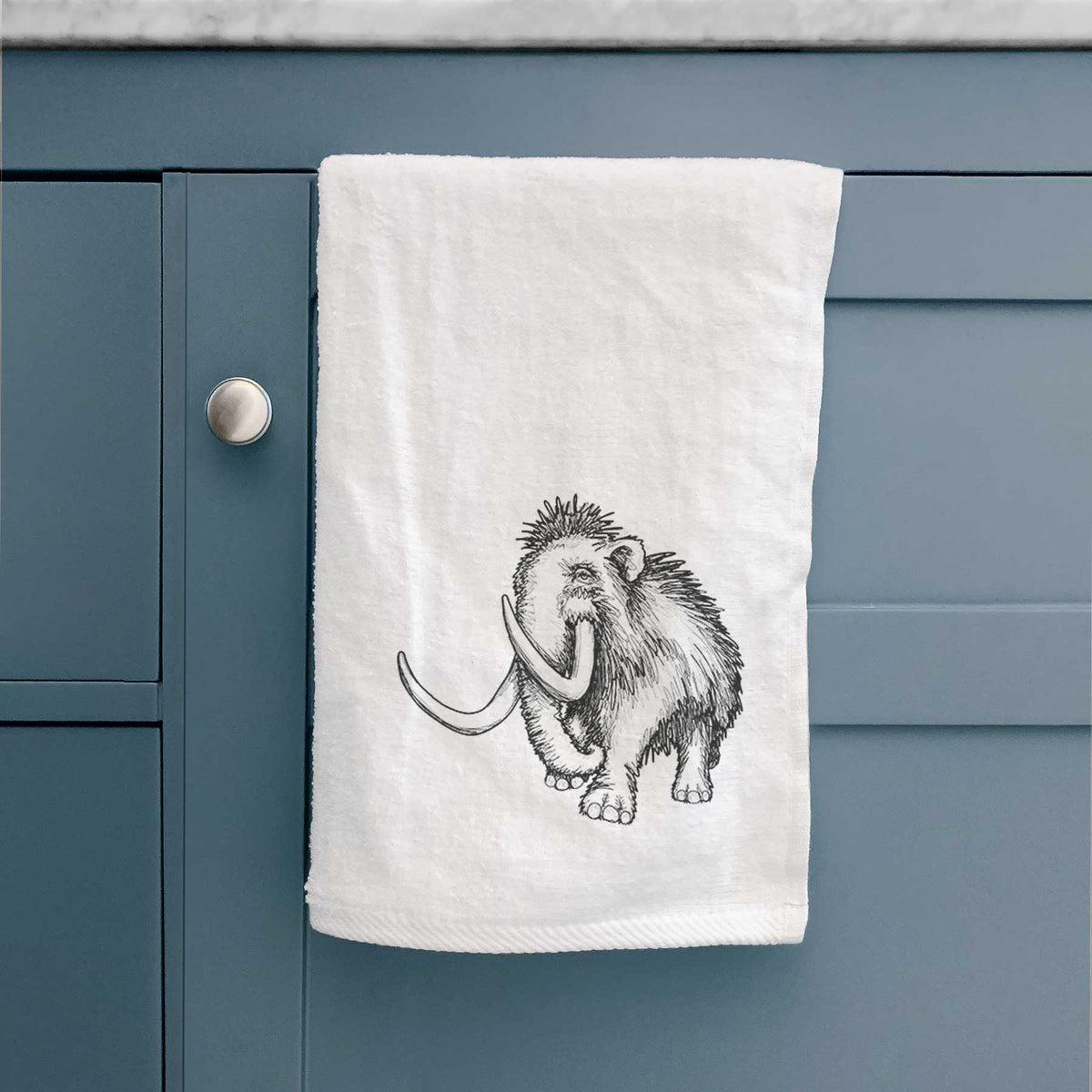 White hand towel printed with a black ink illustration of a woolly mammoth with long curved tusks.