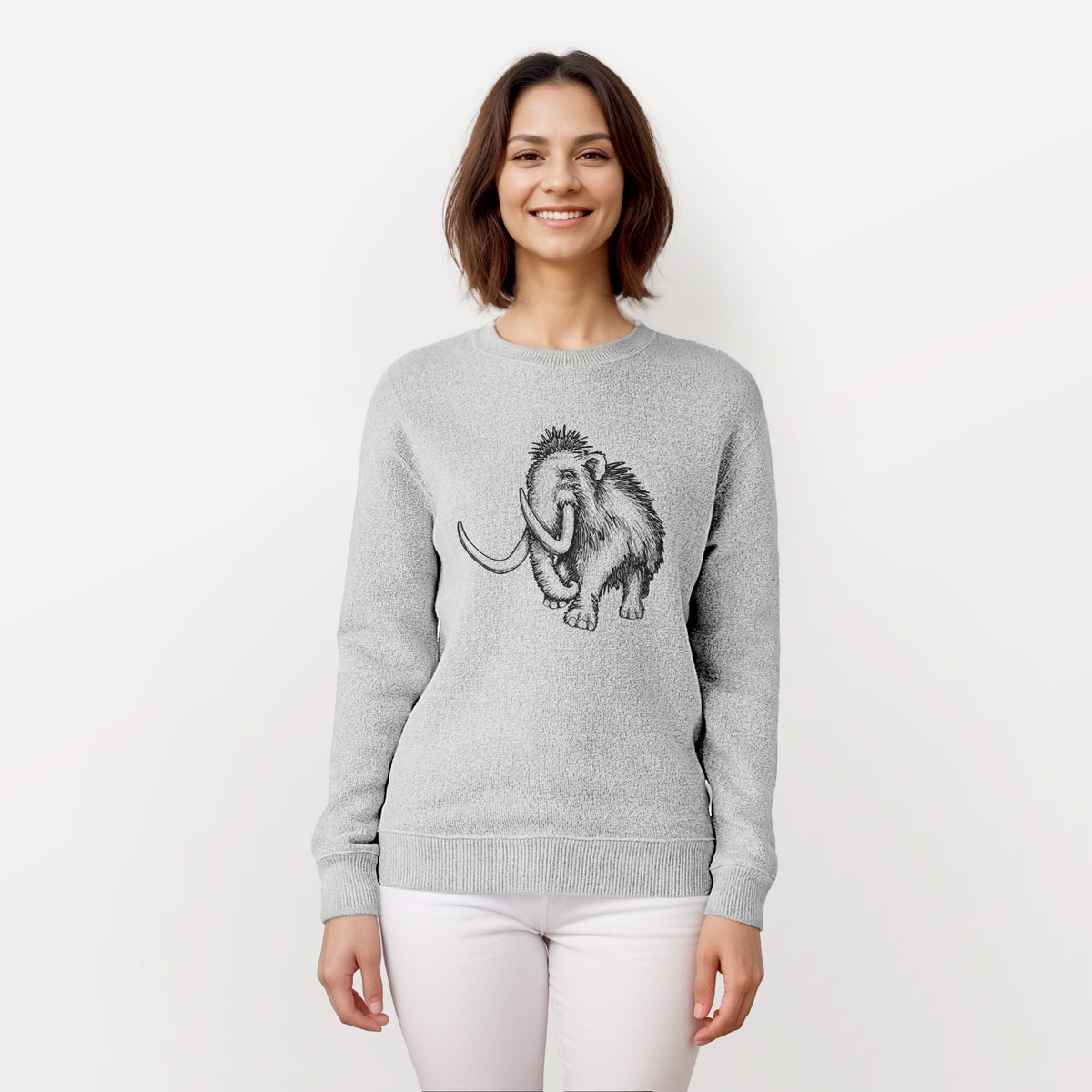 Woman wearing a knit sweatshirt printed with a black ink illustration of a woolly mammoth with long curved tusks.
