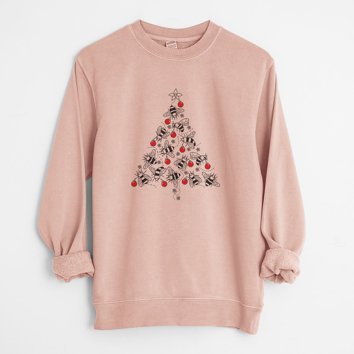 Dusty pink pigment dyed crewneck sweatshirt laid flat with the sleeves rolled, printed with a Christmas tree made of black ink bees with red ornaments and a star on top.