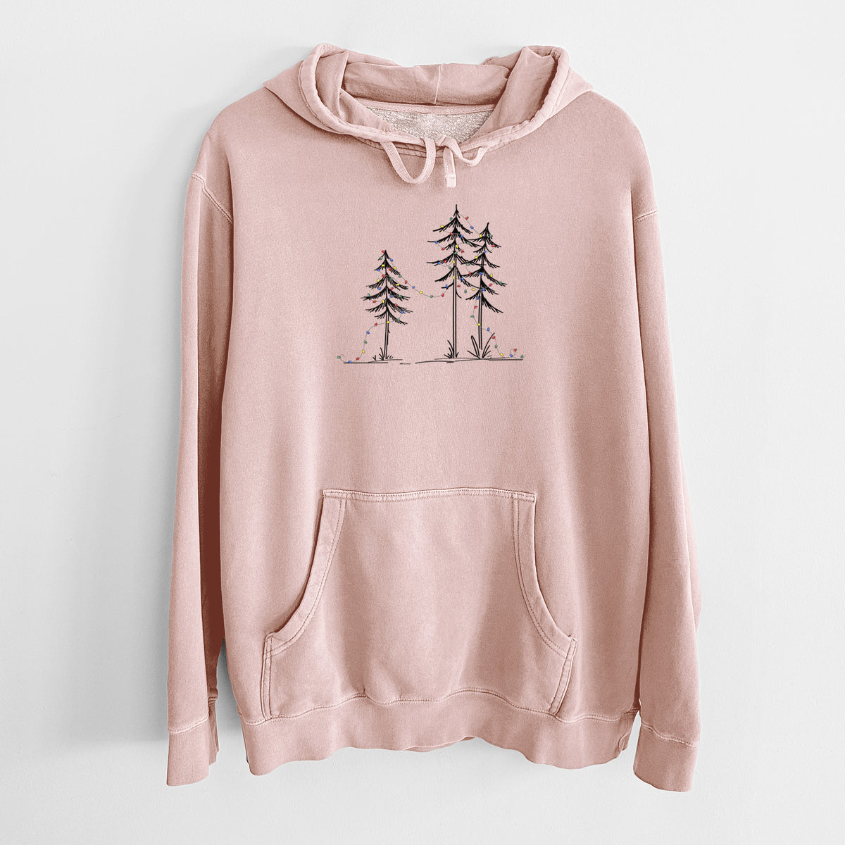 Dusty pink pigment dyed hoodie laid flat, printed with three slender black ink pine trees strung with a garland of multicolored holiday lights.