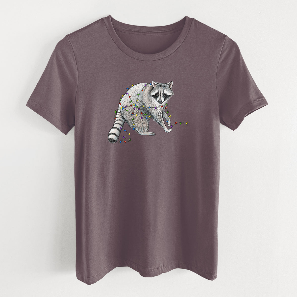 Purple storm women's relaxed fit cotton t-shirt laid flat, printed with a black ink raccoon tangled in a string of colorful holiday lights.