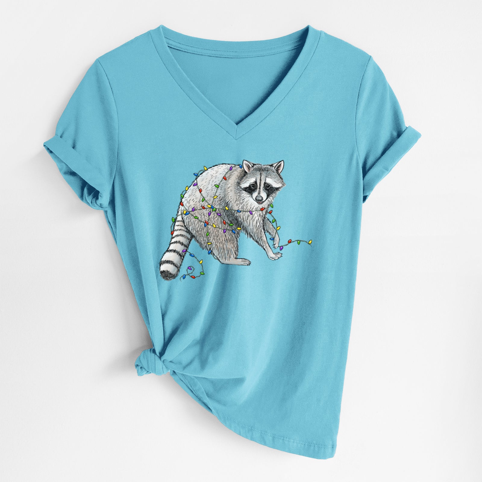 Turquoise women's relaxed fit cotton V-neck t-shirt laid flat, printed with a black ink raccoon tangled in a string of colorful holiday lights.