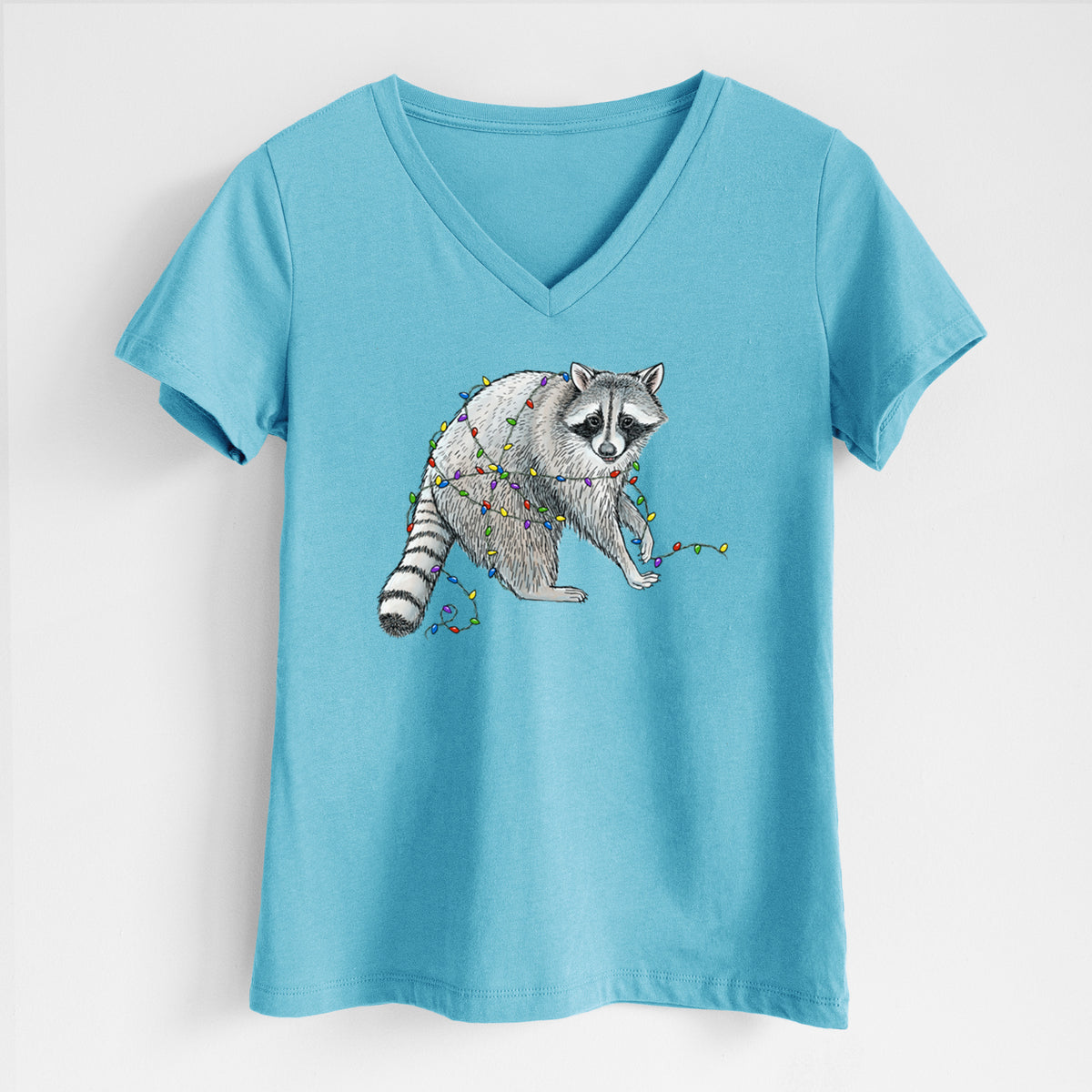 Turquoise women's relaxed fit cotton V-neck t-shirt laid flat, printed with a black ink raccoon tangled in a string of colorful holiday lights.