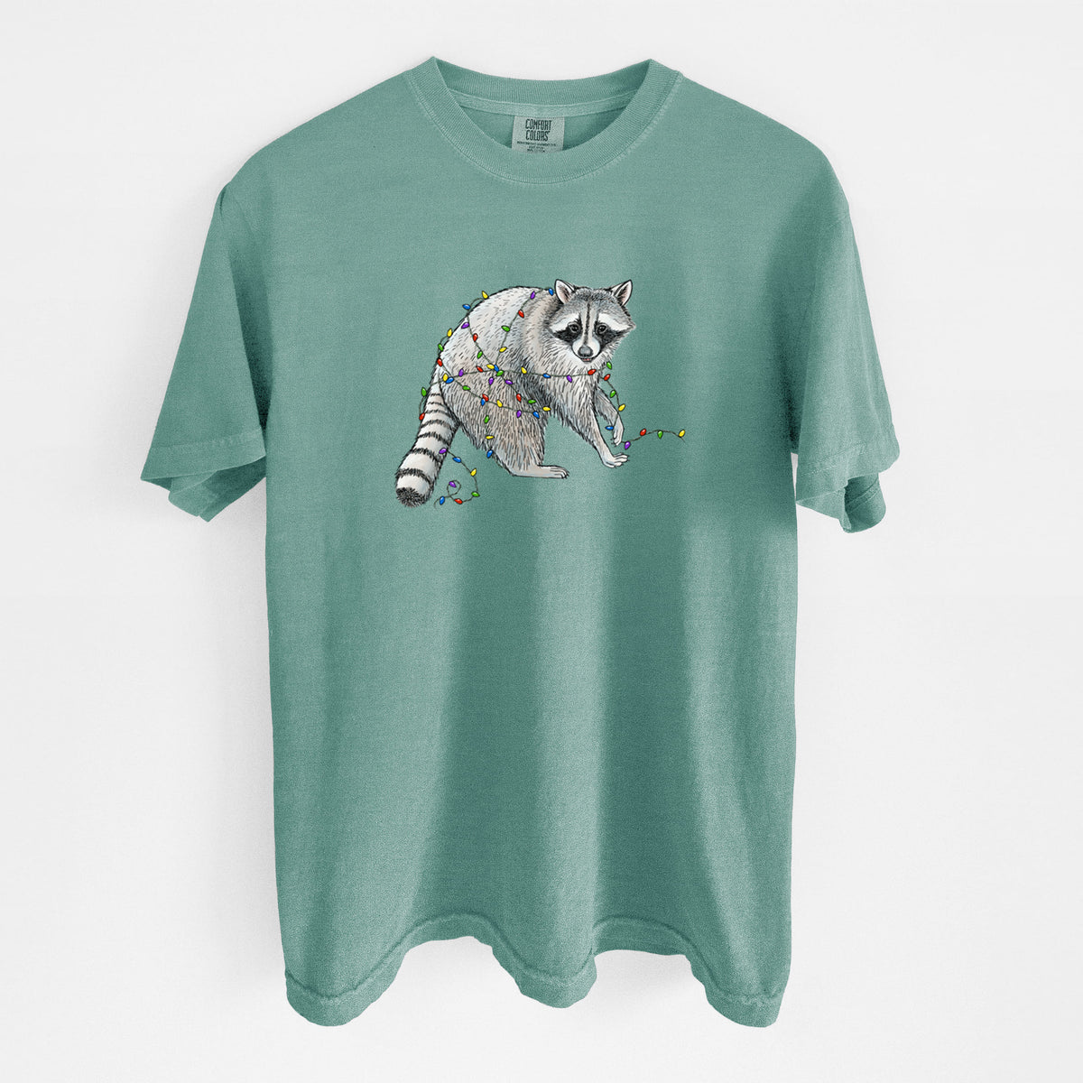 Reef green Comfort Colors t-shirt laid flat, printed with a black ink raccoon tangled in a string of colorful holiday lights.