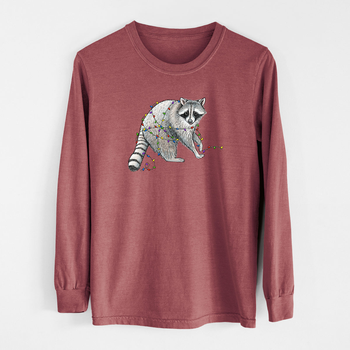 Brick red Comfort Colors long sleeve shirt laid flat, printed with a black ink raccoon tangled in a string of colorful holiday lights.