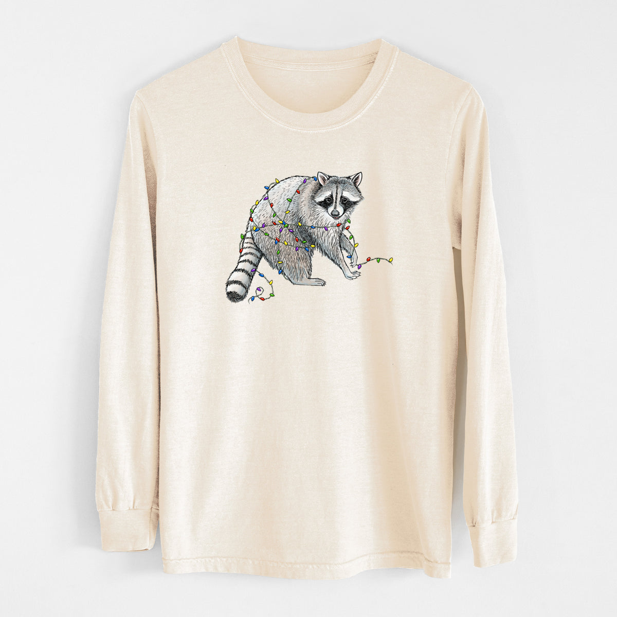 Ivory Comfort Colors long sleeve shirt laid flat, printed with a black ink raccoon tangled in a string of colorful holiday lights.