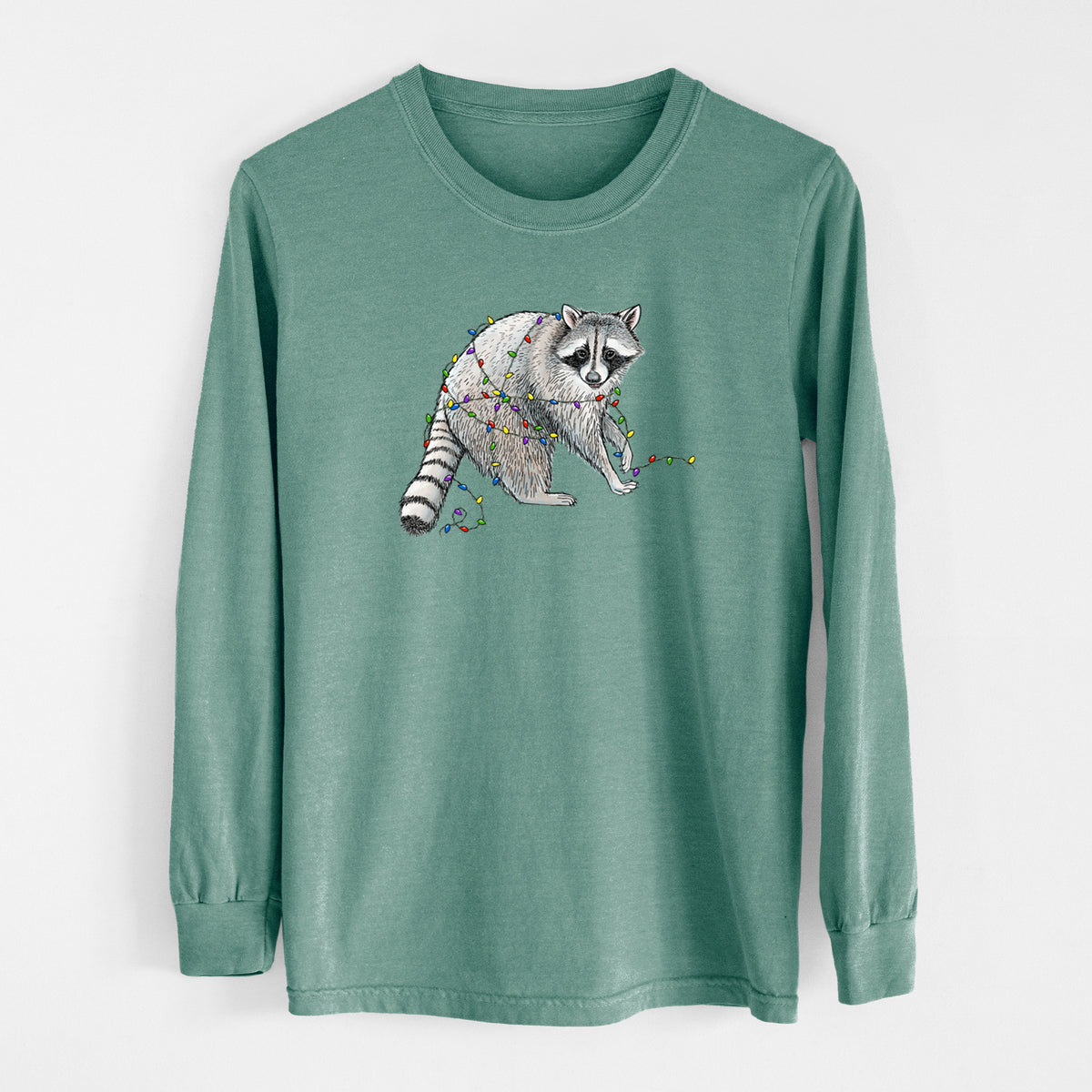 Pine green Comfort Colors long sleeve shirt laid flat, printed with a black ink raccoon tangled in a string of colorful holiday lights.