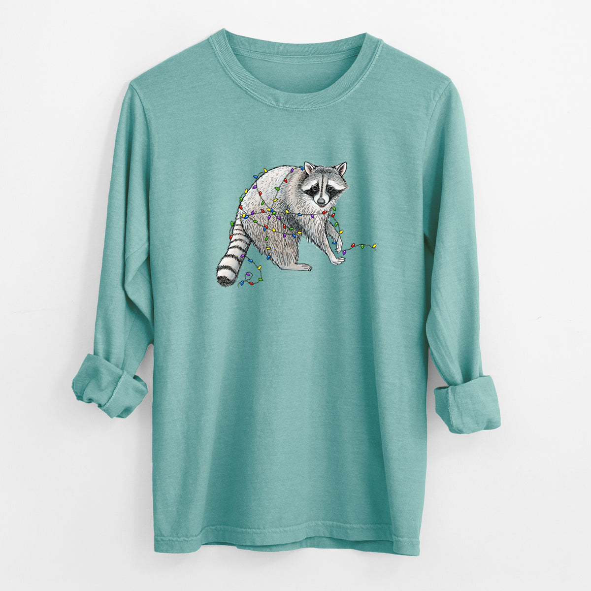 Reef green Comfort Colors long sleeve shirt laid flat with the cuffs rolled, printed with a black ink raccoon tangled in a string of colorful holiday lights.