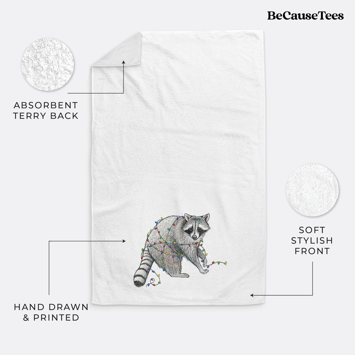 White hand towel printed with a black ink raccoon tangled in a string of colorful holiday lights.