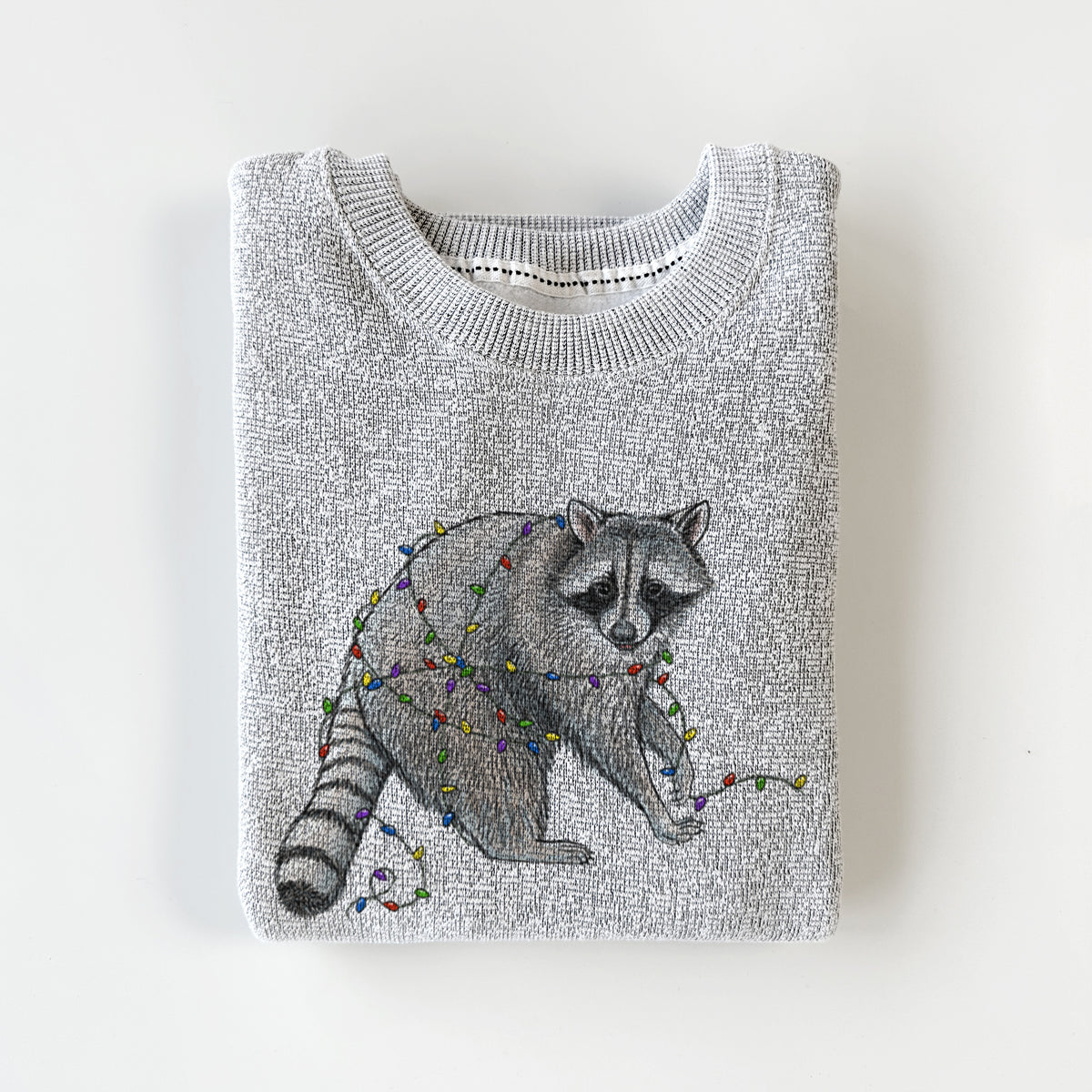 Salt and pepper knit sweatshirt printed with a black ink raccoon tangled in a string of colorful holiday lights, styled flat.