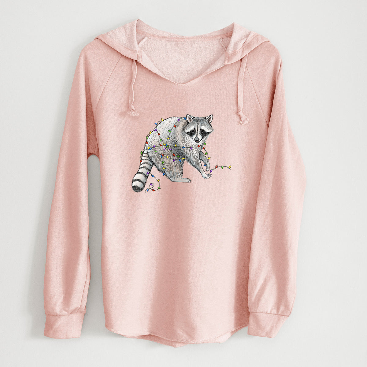 Blush pink women's Cali Wave hooded sweatshirt laid flat, printed with a black ink raccoon tangled in a string of colorful holiday lights.