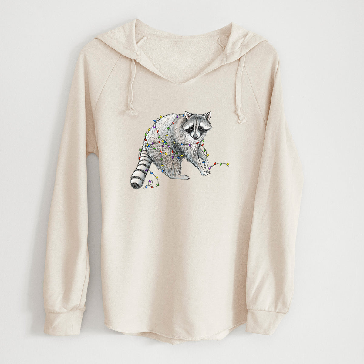 Bone cream women's Cali Wave hooded sweatshirt laid flat, printed with a black ink raccoon tangled in a string of colorful holiday lights.