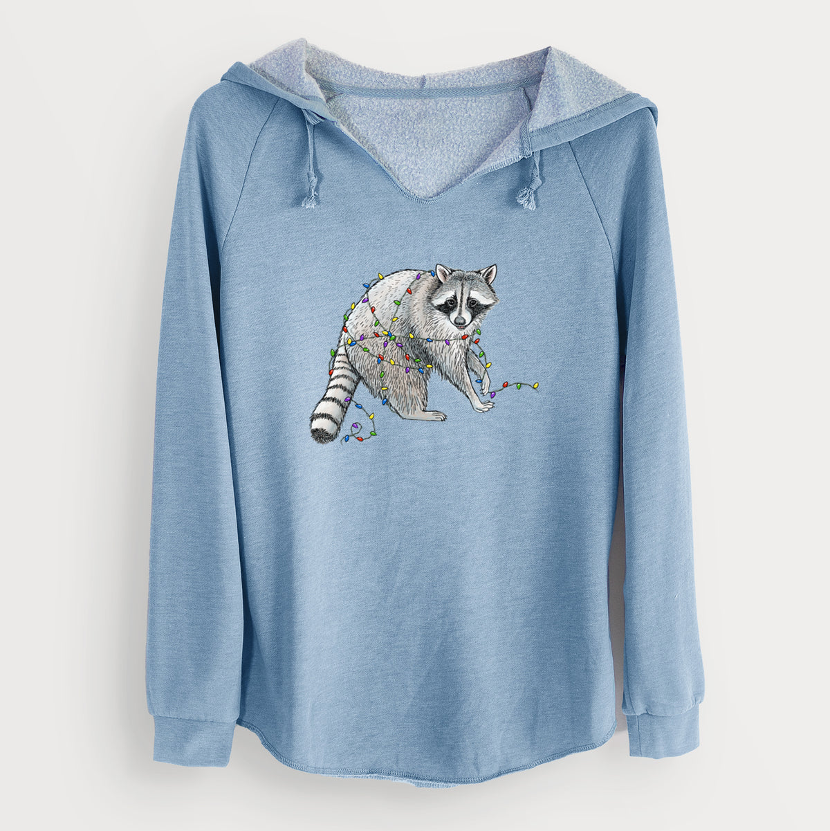 Misty blue women's Cali Wave hooded sweatshirt laid flat, printed with a black ink raccoon tangled in a string of colorful holiday lights.