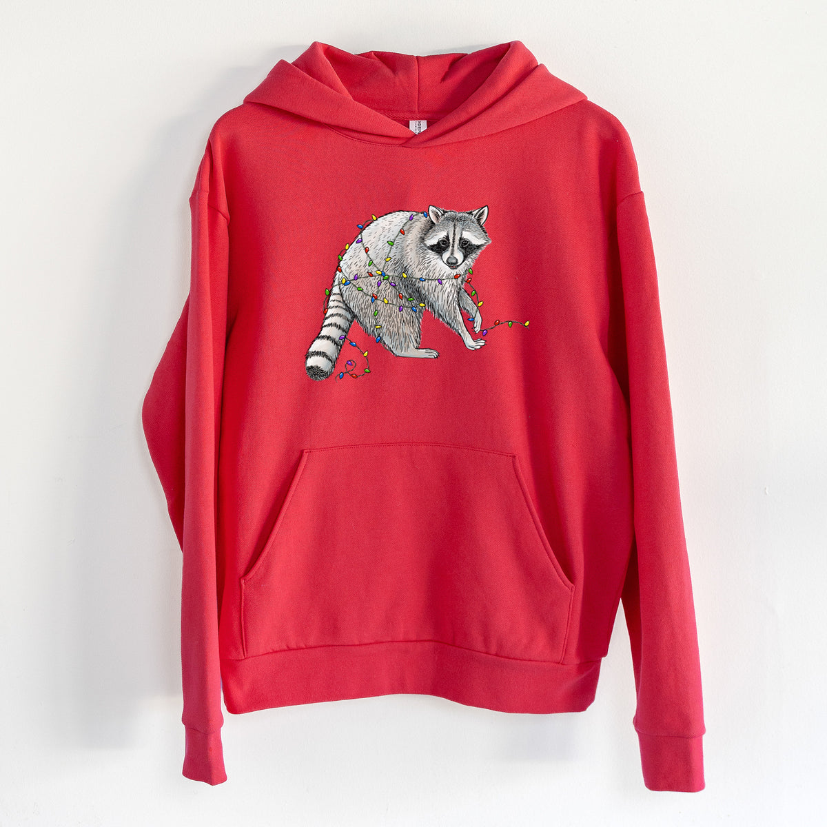 Christmas Raccoon - Statement Midweight Hoodie in Cherry Red, hanging on a white wall, with a front kangaroo pocket and no drawcords.