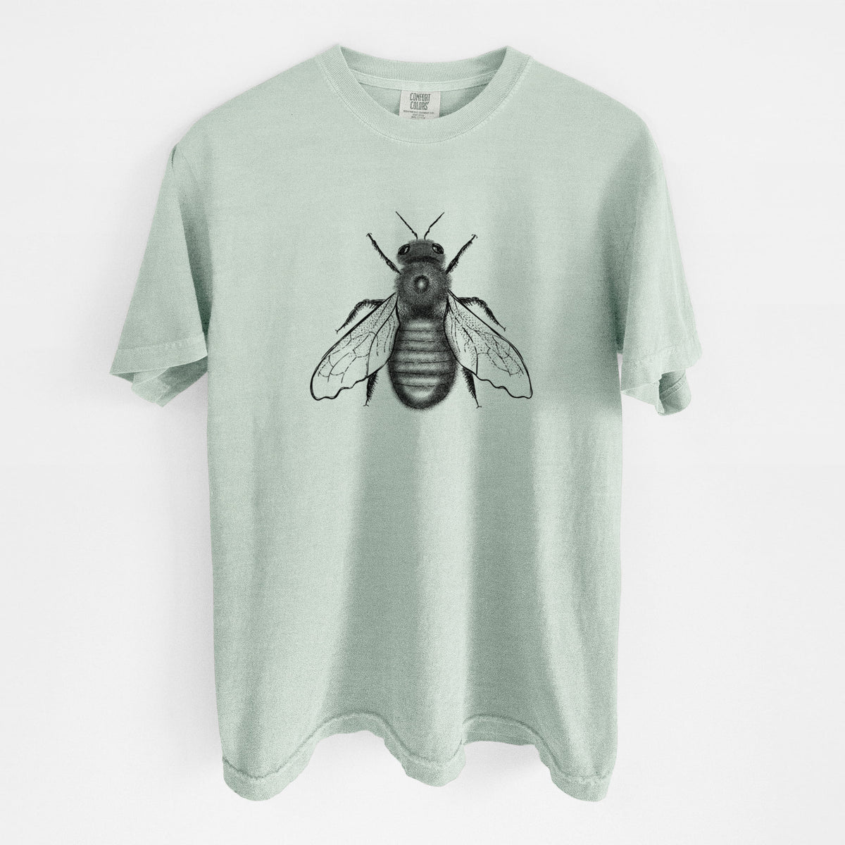 Bay green Comfort Colors t-shirt laid flat, printed with a detailed black ink illustration of an eastern carpenter bee with its wings spread, seen from above.