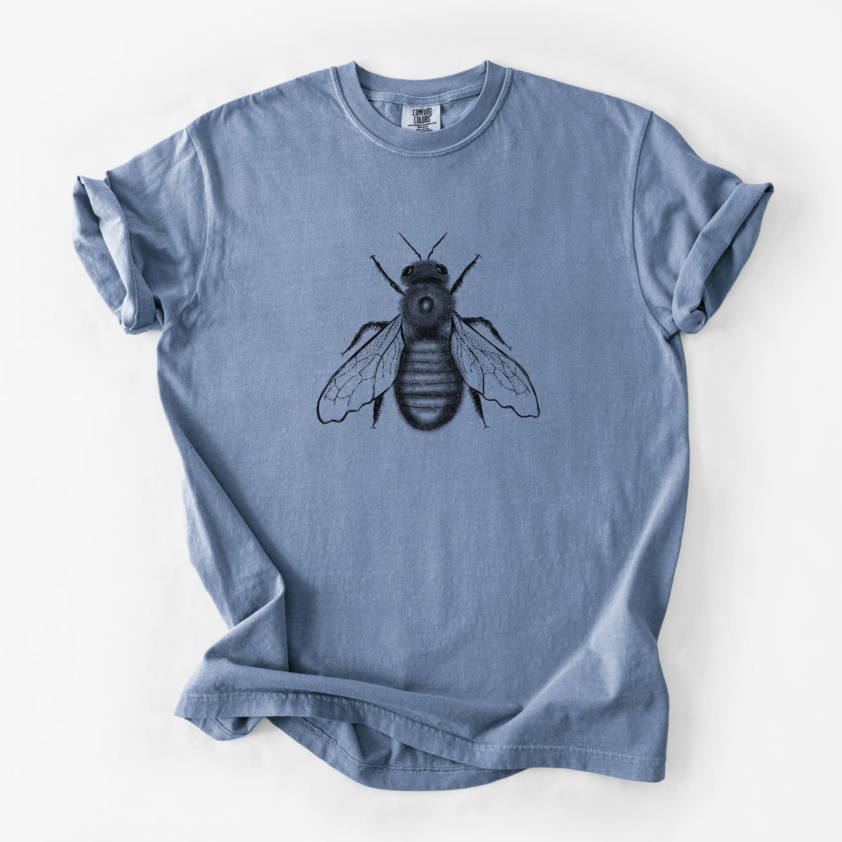 Blue jean Comfort Colors t-shirt laid flat, printed with a detailed black ink illustration of an eastern carpenter bee with its wings spread, seen from above.