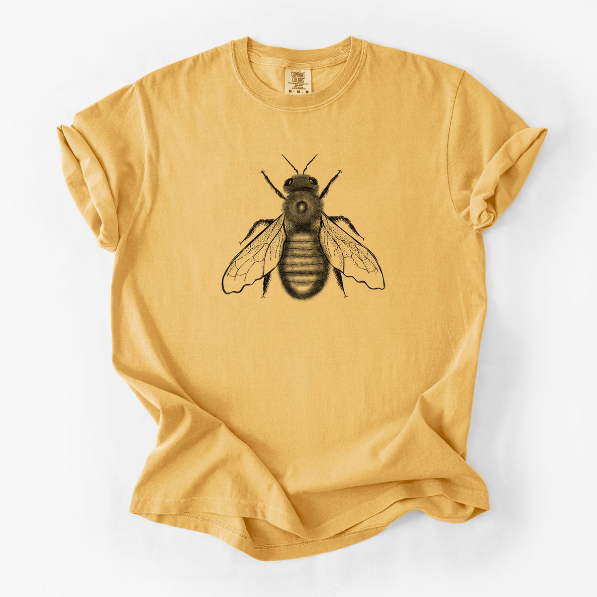 Golden wheat yellow Comfort Colors t-shirt laid flat, printed with a detailed black ink illustration of an eastern carpenter bee with its wings spread, seen from above.