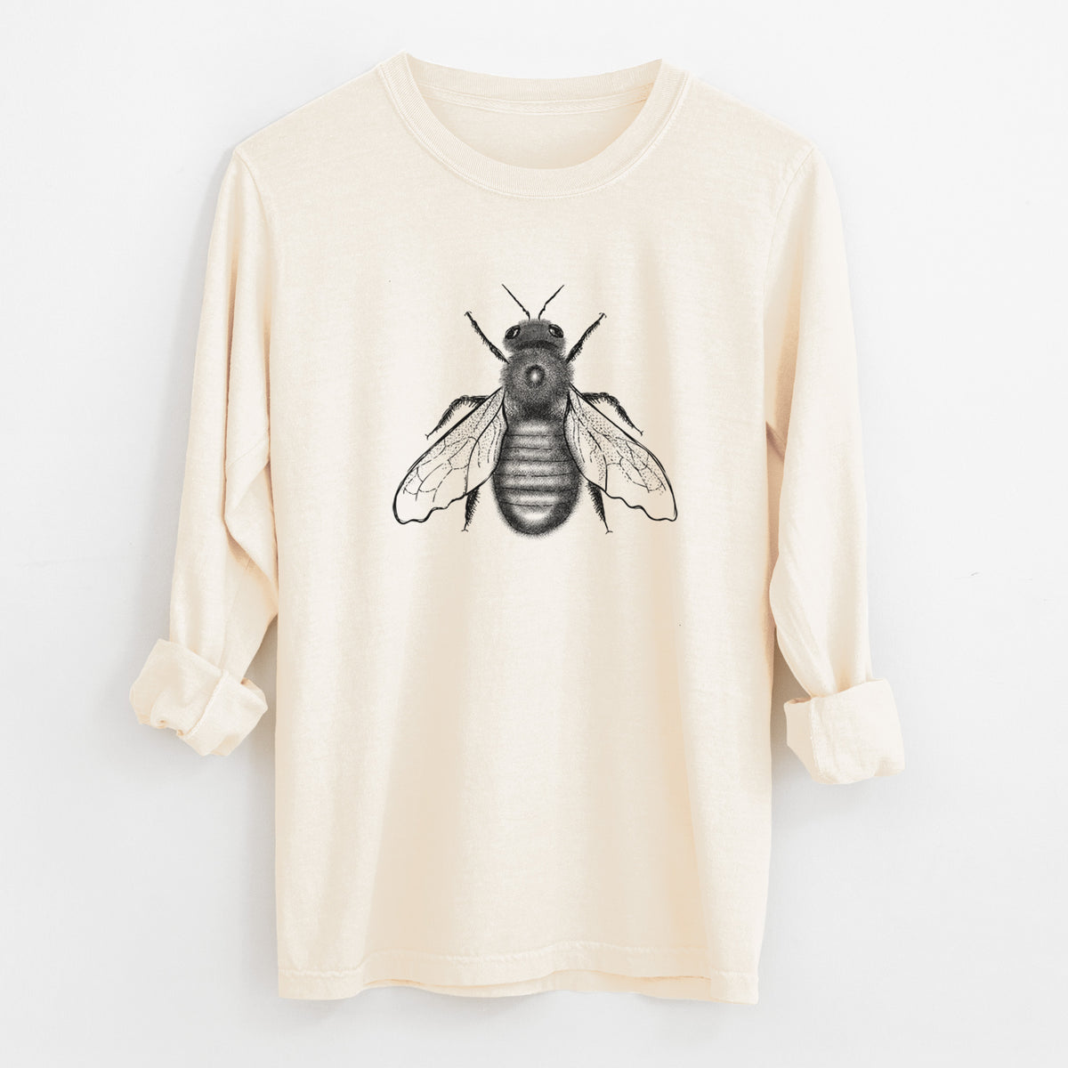 Ivory Comfort Colors long sleeve shirt laid flat with the cuffs rolled, printed with a detailed black ink illustration of an eastern carpenter bee with its wings spread, seen from above.