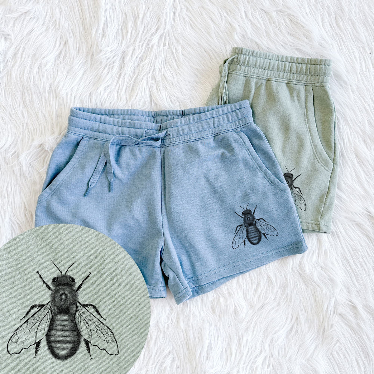 Two pairs of Cali Wave shorts in different colors printed with a detailed black ink illustration of an eastern carpenter bee with its wings spread, seen from above, with a close-up of the print.