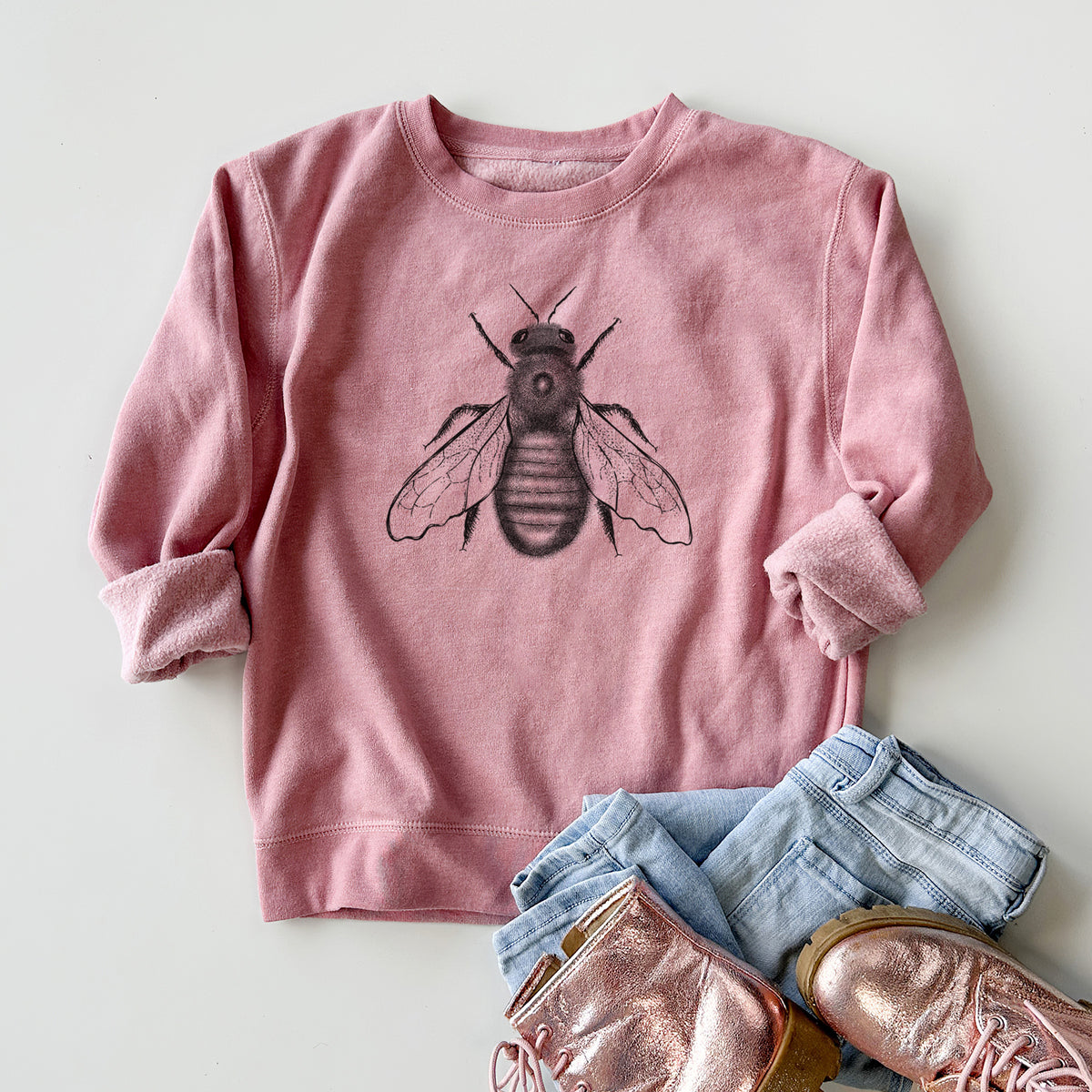 Youth crewneck sweatshirt printed with a detailed black ink illustration of an eastern carpenter bee with its wings spread, seen from above, styled flat with jeans and boots.