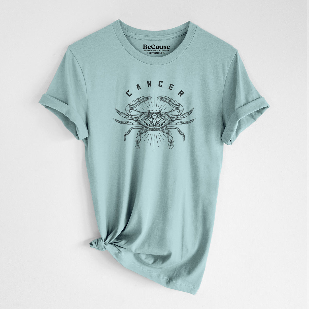 Dusty blue lightweight cotton t-shirt laid flat with the sleeves rolled, printed with a black ink crab with the word Cancer, for the Cancer zodiac sign.