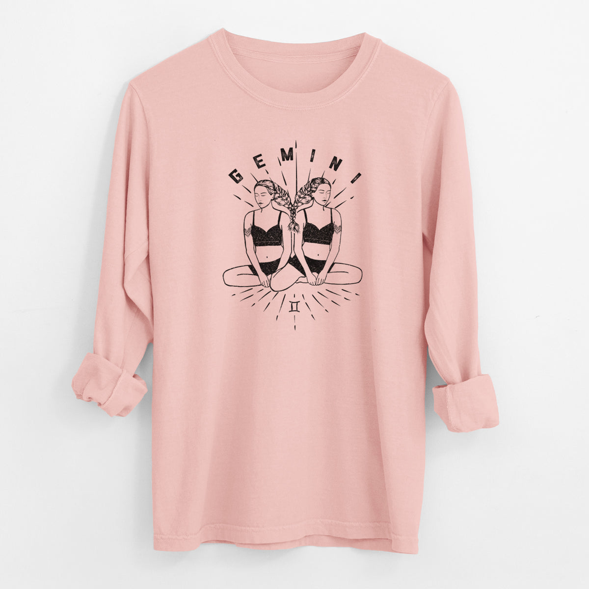Peachy Comfort Colors long sleeve shirt laid flat with the cuffs rolled, printed with black ink twin women sitting back to back with the word Gemini, for the Gemini zodiac sign.