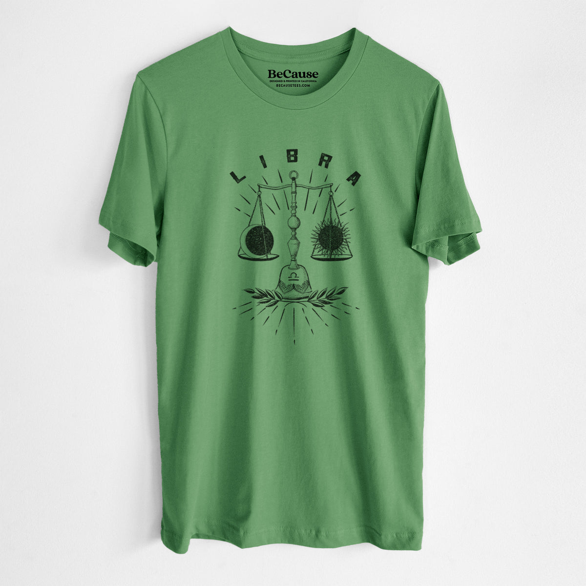 Leaf green lightweight cotton t-shirt laid flat, printed with a black ink set of balance scales with the word Libra, for the Libra zodiac sign.
