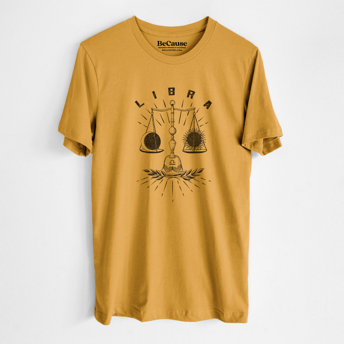 Mustard yellow lightweight cotton t-shirt laid flat, printed with a black ink set of balance scales with the word Libra, for the Libra zodiac sign.