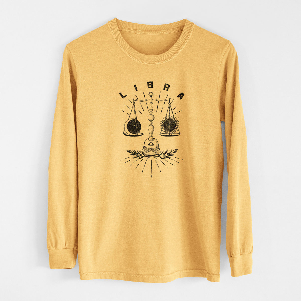 Golden wheat yellow Comfort Colors long sleeve shirt laid flat, printed with a black ink set of balance scales with the word Libra, for the Libra zodiac sign.