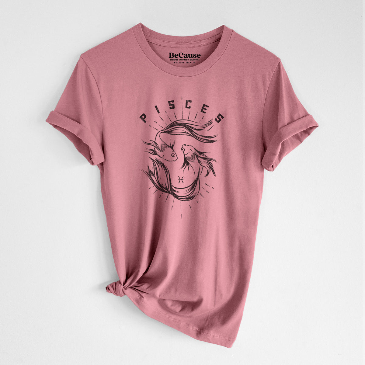 Mauve pink lightweight cotton t-shirt laid flat with the sleeves rolled, printed with two black ink fish swimming in a circle with the word Pisces, for the Pisces zodiac sign.
